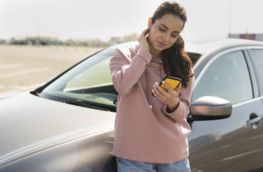 Mulher encostada no carro solicitando assistência 24 horas após uma pane elétrica no carro.